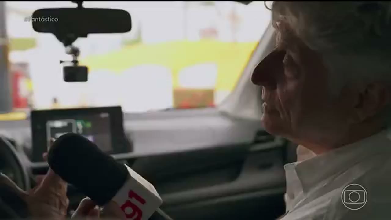 Caco Barcellos conversa com um jornalista dentro de um carro